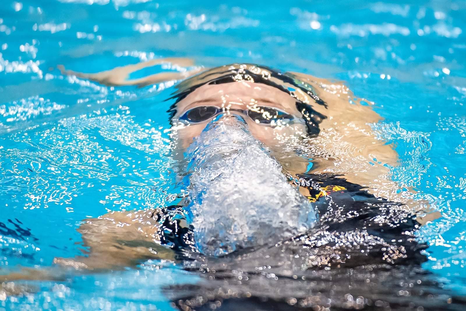 Adult swimmer training backstroke in the pool